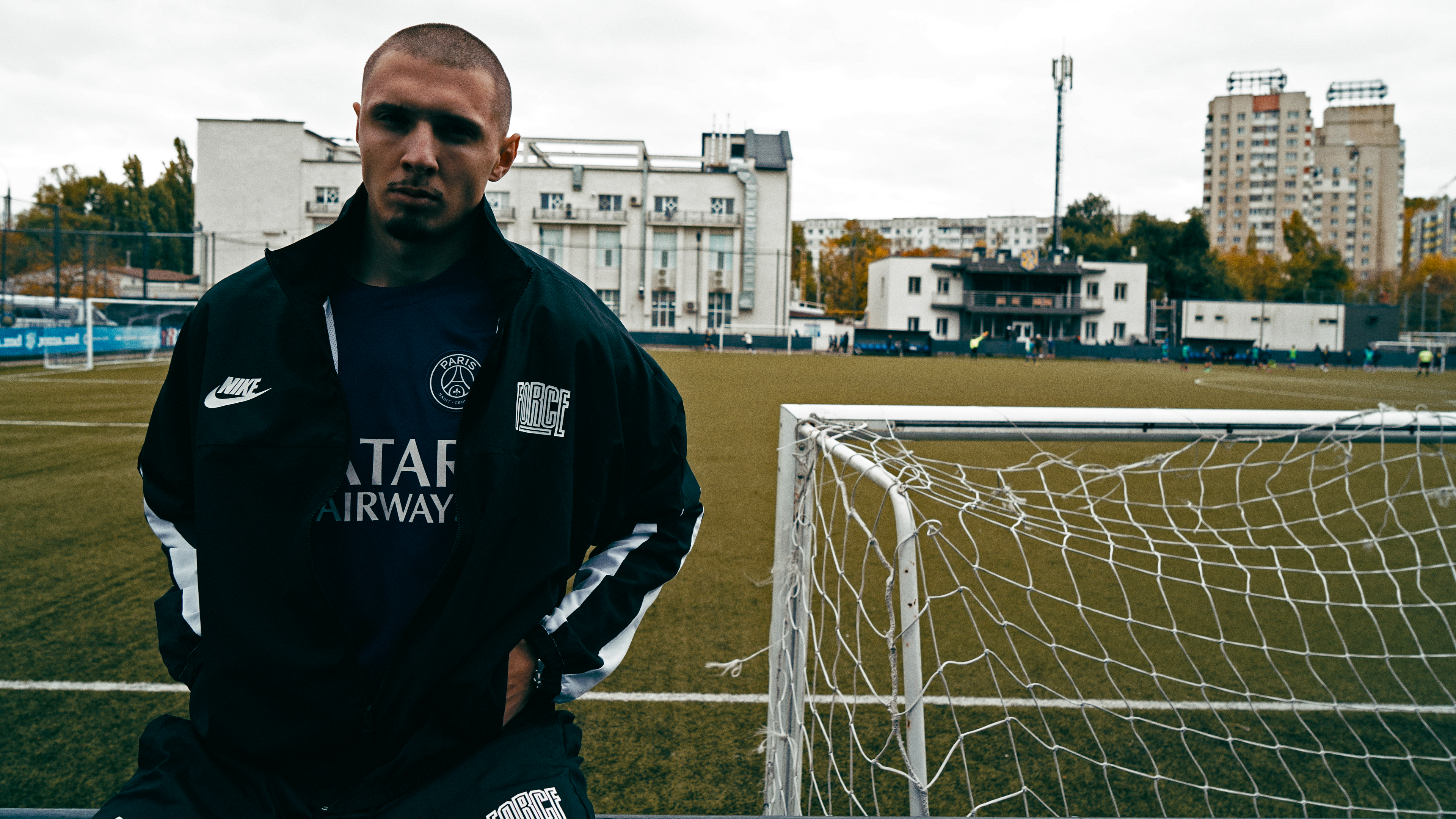 Person standing on a soccer field with a goalpost in the background